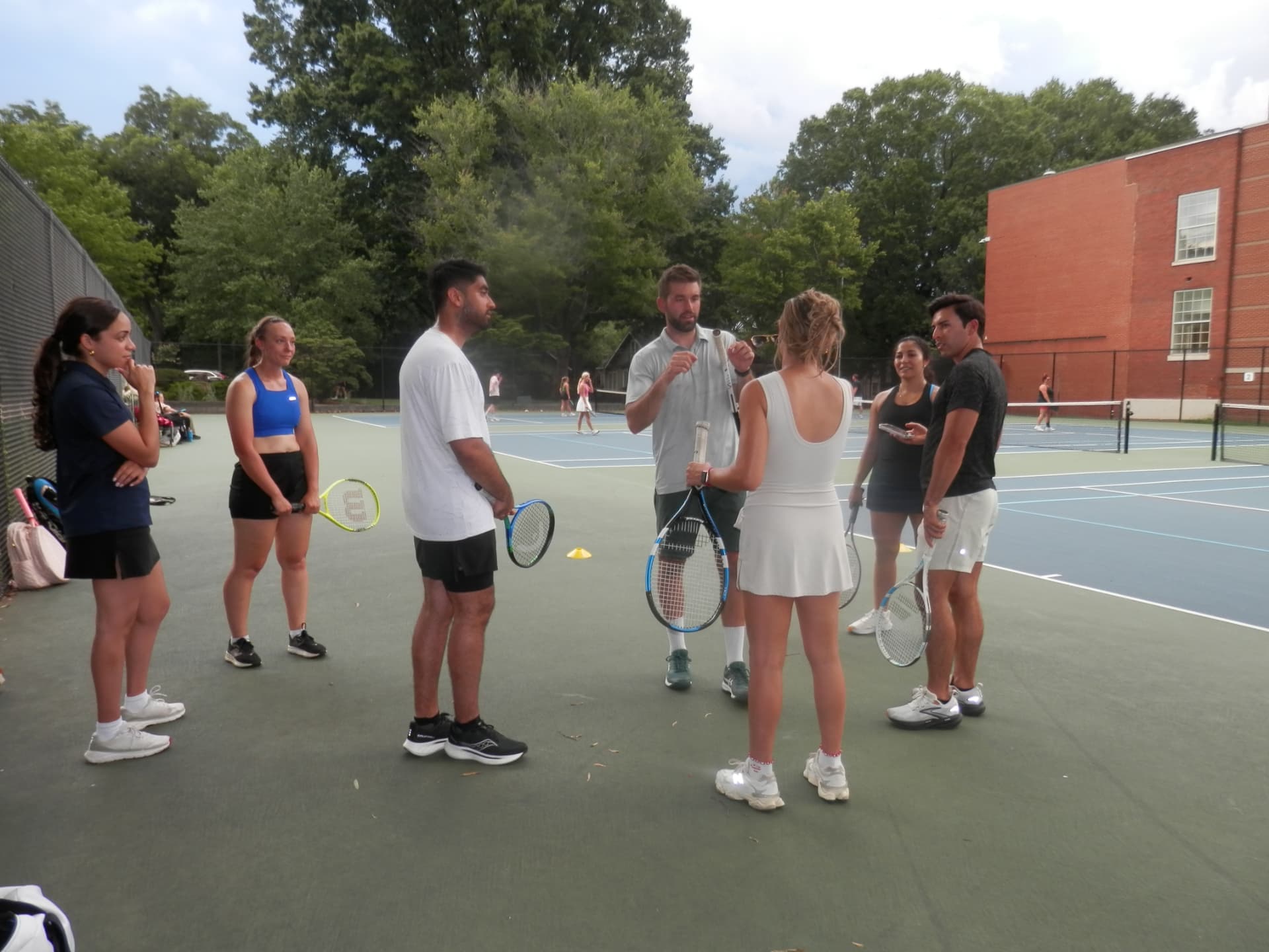 A coach talking to the Tardeo group on court